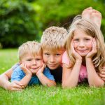 Jarní focení dětí - tři děti leží na trávě